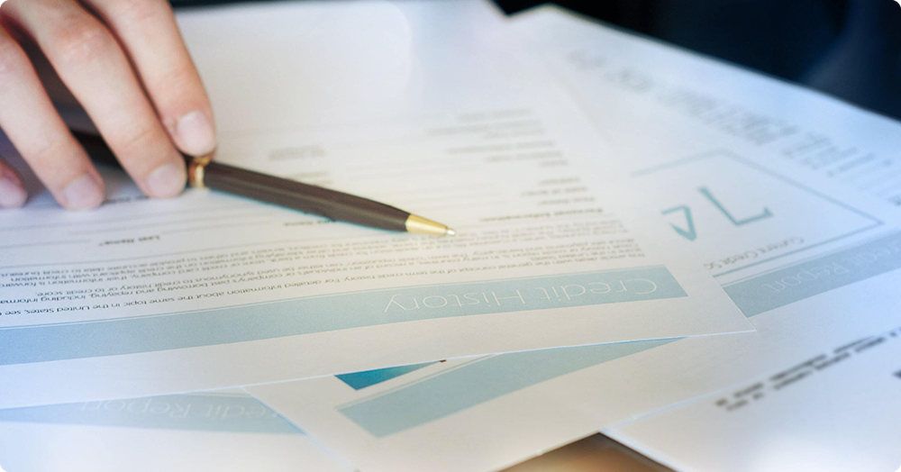 Close-up of a Landlord reviewing documents related to credit bureau reporting and Tenant credit history